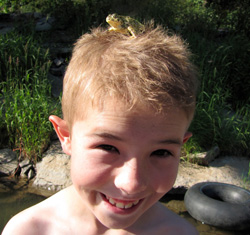 Boy at the river catching frogs